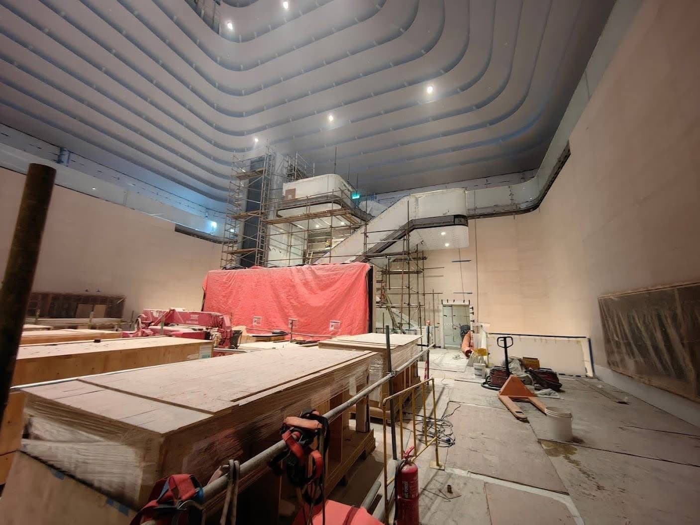 Upper atrium floor with crated stone panels and lifting plant