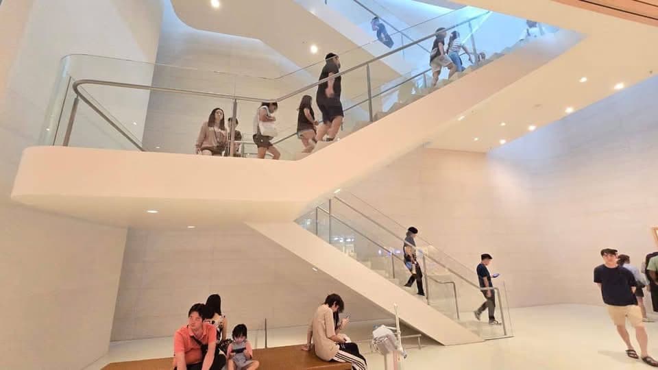 White sculpted feature stair with glass balustrades connecting the store levels