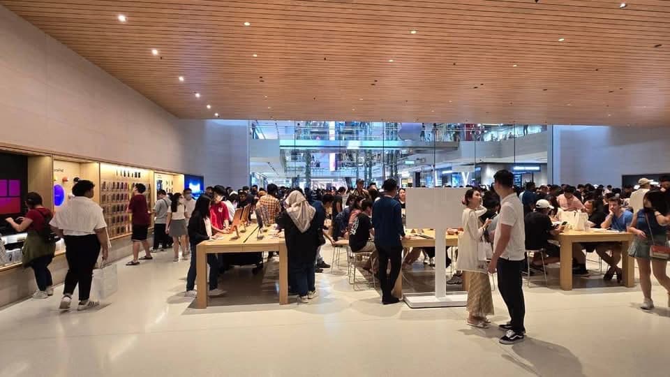 Sales floor under a timber slatted ceiling with Apple product tables