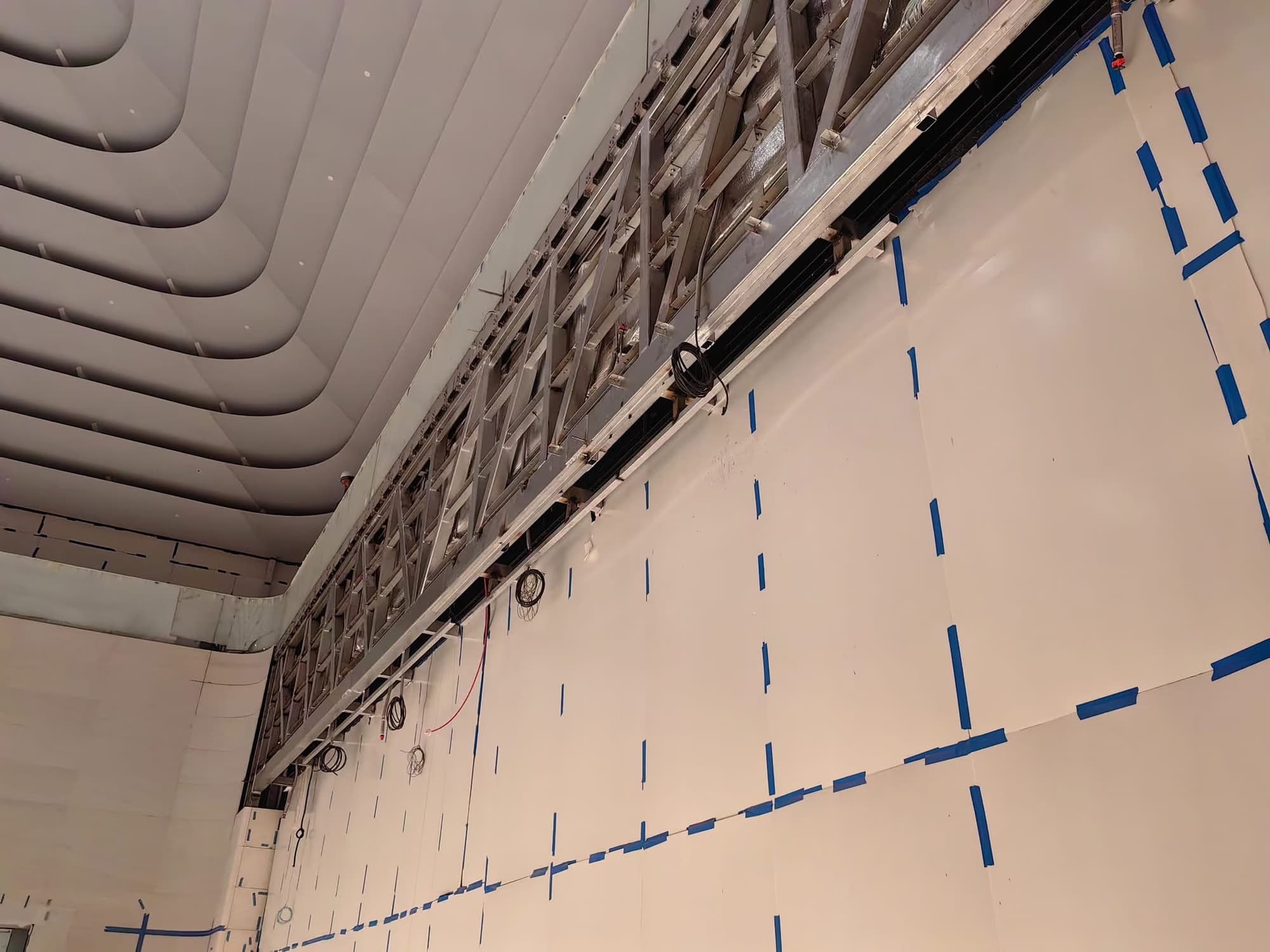 Long-span steel truss running above the forum wall, beneath the ceiling ribs